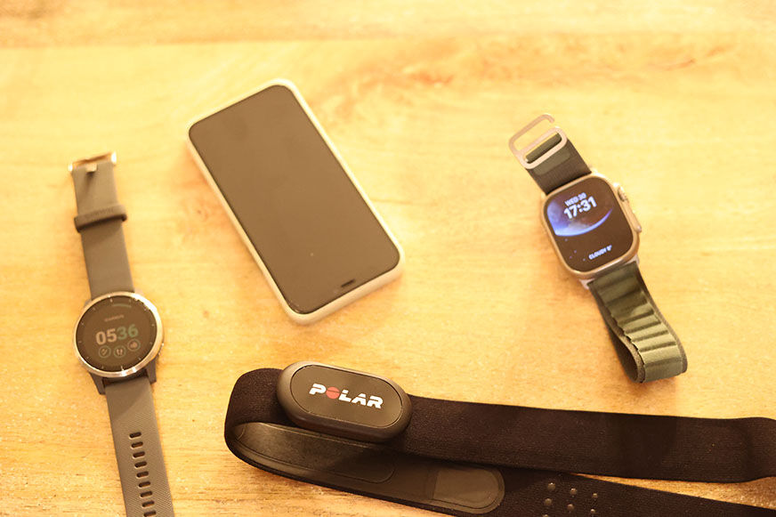 Man sieht die iWatch Ultra mit einem iPhone, der Garmin vivoactive4 und einem Brustgurt.